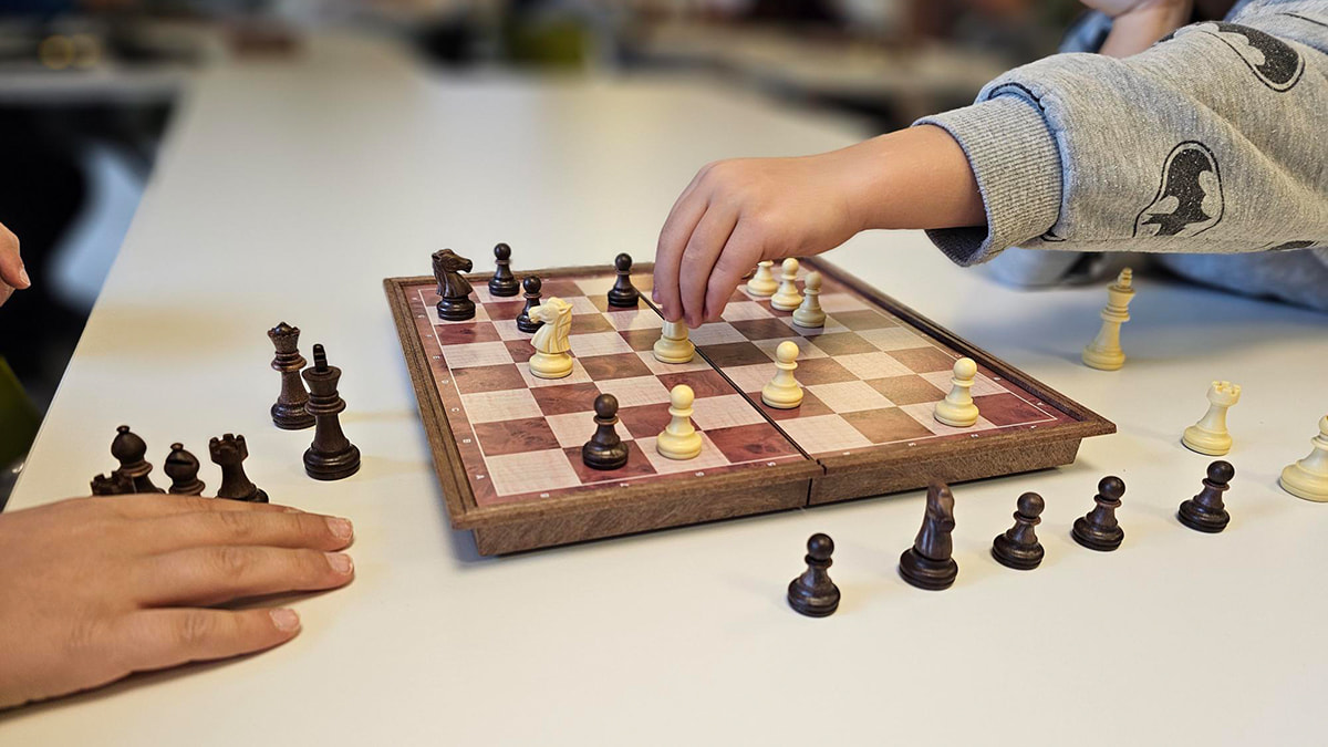 Kinder spielen Schach auf einem Schachbrett.
