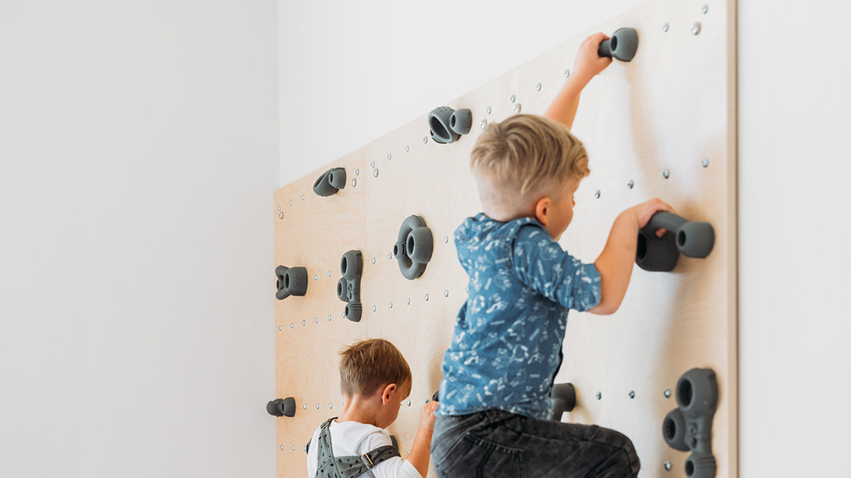 Zwei Kinder klettern an der Indoor-Kletterwand.